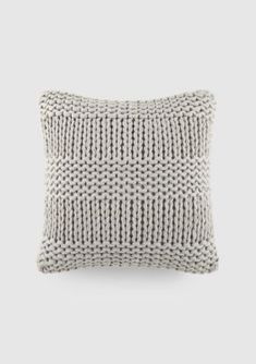 a gray and white pillow on a grey background