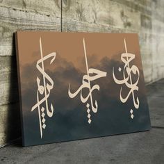 three arabic calligraphys are displayed on a wooden paneled wall with clouds in the background