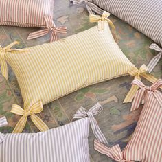 four pillows with bows tied around them on a couch