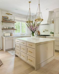 a large kitchen with an island in the middle and lots of cabinets on both sides