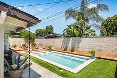 a backyard with a pool and artificial grass