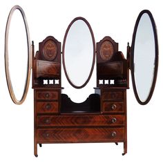 an antique dresser with three mirrors on it