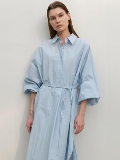 This long shirt dress from Atelier Nain features a wide placket and a half-open design, offering comfort without the gap between buttons.- With a belt to accentuate the waistline- Oversized fit for comfortable wear experience- The uneven hemline to add a unique point of interest* Model shots may differ from the actual product color due to shooting location, time, and graphic techniques. Refer to the product cut images for the actual color. Spring Shirt Dress With Tie Waist And Relaxed Fit, Spring Relaxed Fit Shirt Dress With Tie Waist, Summer Cotton Shirt Dress With Belted Cuffs, Spring Button-up Belted Dress For Daywear, Relaxed Fit Belted Shirt Dress For Spring, Spring Relaxed Fit Belted Shirt Dress, Spring Midi Shirt Dress With Roll-up Sleeves, Relaxed Fit Shirt Dress With Tie Waist For Daywear, Spring Midi Dress With Belted Cuffs For Daywear