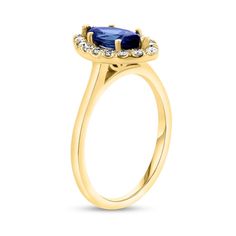 a yellow gold ring with an oval shaped blue sapphire and diamonds on the sides, set in