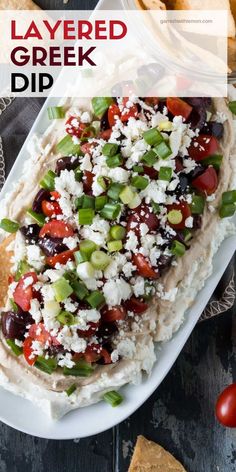 layered greek dip on a plate with pita bread