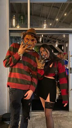 a man and woman dressed up in costumes standing next to each other with their faces painted