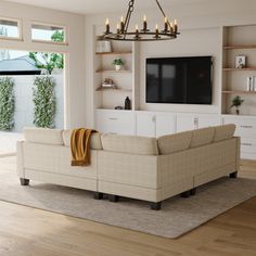 a living room with white furniture and a large screen tv