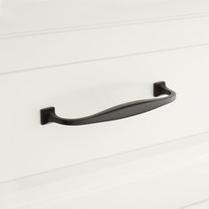 a black handle on a white cabinet door