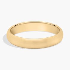 a yellow gold wedding ring with a thin band on the outside and an oval edge