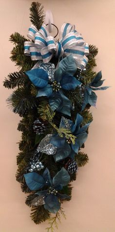 a blue and white christmas wreath hanging on the side of a wall next to a clock