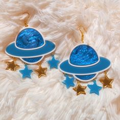 *These out of this world Saturn earrings are made with so many fun and interesting details. *They were laser cut with white, detailed blue, teal, and gold acrylic. *Three star charms are attached under each Saturn piece. *The pieces were then added to hypoallergenic gold tone earring hooks. **These earrings can be made with sterling silver hooks, regular posts, or wrap around hooks -- if you prefer any of these options just let us know in the notes to seller section during checkout! CONTACT: *Fe Novelty Blue Drop Earrings, Fun Handmade Blue Jewelry, Themed Blue Earrings For Gifts, Blue Themed Earrings For Gift, Blue Celestial Pierced Earrings, Themed Blue Earrings For Gift, Celestial Blue Pierced Earrings, Blue Fun Dangle Jewelry, Blue Handmade Novelty Earrings