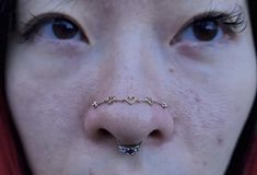 a close up of a person with a nose ring on their nose and the nose piercing is heart shaped