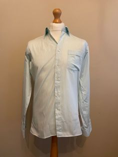 Striking 80s vintage shirt in mint green with tonal shadow stripe pattern cotton polyester blend from the Europa Collection by Van Heusen.  Details: straight collar, long sleeves, barrel cuffs, regular fit.  As new (only unwrapped for photo shoot) 50% Cotton 50% Polyester  Made in England  Size M Chest 40" Collar 15" Measurements Flat  Pit to Pit 20" 50cm Shoulder to Shoulder 17" 44cm Sleeve 26" 67cm Length 31" 79cm Semi-formal Striped Long Sleeve Shirt, Striped Long Sleeve Shirt For Semi-formal Occasions, Green Long Sleeve Business Top, Green Long Sleeve Tops For Business, Green Collared Shirt For Semi-formal Occasions, Business Long Sleeve Green Shirt, Semi-formal Striped Long Sleeve Tops, Striped Long Sleeve Semi-formal Tops, Business Green Long Sleeve Shirt