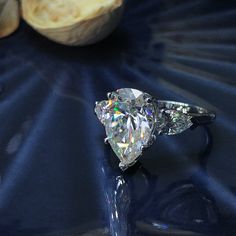 a diamond ring sitting on top of a table next to some bananas and an apple