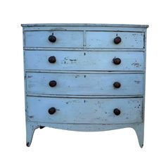 an old blue dresser with knobs on it's sides and drawers, against a white background