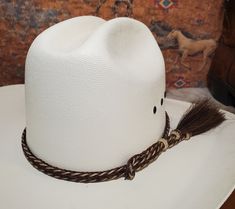 Braided Horse Hair Adjustable Hat Band with 2 Side Tassels and a loop and sliding hitched knot that make this hatband a great fit for most hats. This stunning hat band is made from genuine braided horse hair and will compliment your favorite cowboy hat.   - Available in Grey/Black, Black/White, Brown/White, Sorrel/White (other colors available upon request) -  2 braided strands are sewn together to create this gorgeous hatband. - Incudes 2 horse hair tassels that measure 3 1/4" long - Hat band measurements: approximately adjusts to 27" around and is 3/8 inch wide - Hat bands are shown on a size 7 hat.  Hats are not included. - See my horse hair KEEPSAKES to have a hat band made from your horse's hair:  https://www.etsy.com/shop/BlueEyesDesignsHB?ref=seller-platform-mcnav§ion_id=43697745 - White Adjustable Country Style Top Hat, White Adjustable Fit Hat Band For Rodeo, Adjustable High Crown White Hat, White Adjustable High Crown Hat, Adjustable White Top Hat For Rodeo, Custom White Hat Bands One Size Fits Most, Custom White Hat Bands, White High Crown Adjustable Mini Hat, White Adjustable High Crown Mini Hat