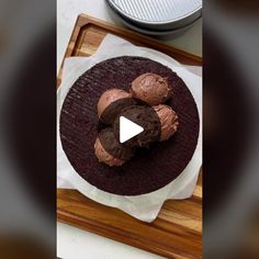 a chocolate cake sitting on top of a wooden cutting board