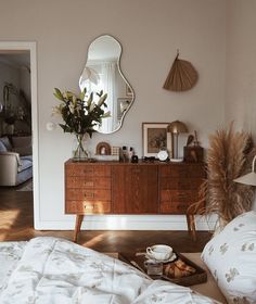 a bedroom with a bed, dresser and mirror on the wall next to each other