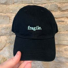 Inject a touch of personalised flair into your ensemble with our Embroidered Small Word Dad Cap - Customisable. This versatile cap allows you to choose any word, name, or small slogan to be tastefully embroidered on the front, creating a unique accessory that truly reflects your individuality. With two cap styles and a wide range of colour options, you can customise your cap to perfectly match your style. Cap Styles:     Vintage Canvas Cap:         Colourways available: Black, Light Denim, Dark Denim, Olive, Stone, Sand, Red, Pink, Cornflower, Bottle Green.         Classic and durable canvas material for a timeless look.         Perfect for adding a touch of vintage charm to any outfit.     Classic Cotton 'Dad' Cap:         Colourways available: Beige, Black, Navy, Mint Green, Pink, Pale B Adjustable Cotton Trucker Hat With Embroidered Logo, Cotton Baseball Cap With Custom Logo, Cotton Snapback Hat With Letter Embroidery, Adjustable Dad Hat With Embroidered Text And Curved Brim, Cotton Snapback Hat With Letter Embroidery And Flat Bill, Adjustable Dad Hat With Embroidered Text, Trendy Black Hat With Letter Embroidery, Adjustable Cotton Baseball Cap With Custom Logo, Cotton Trucker Hat With Letter Embroidery