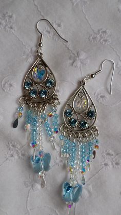 a pair of earrings with blue beads hanging from them