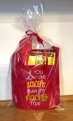 a red bag with some writing on it sitting on a wooden floor next to a white wall