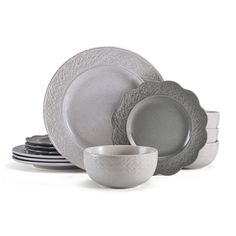 a set of gray and white dinnerware on a white background with place settings in the middle