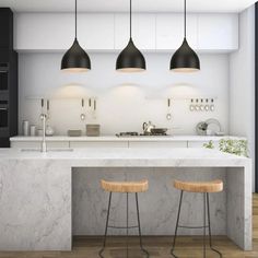 three stools sit in front of an island with marble countertops and black pendant lights