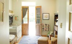 a baby's room with a white crib and striped rug