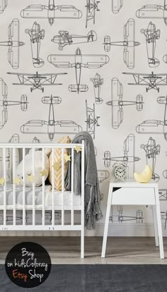 a baby's room with an airplane wallpaper and white crib in the foreground