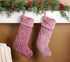 two christmas stockings hanging from a mantel