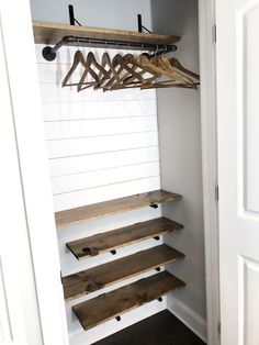 an empty closet with wooden shelves and clothes hangers