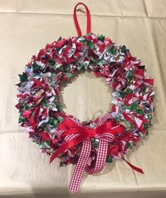 a red and white christmas wreath hanging on a wall