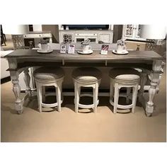 a dining room table with four stools around it