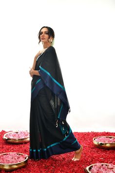 Crafted with care and expertise, this Handwoven Pure black Soft cotton by Kora Banarasi saree offers a unique look. Boasting a striking blue mashru silk border and a luxurious black color, this saree exudes a classy, elegant feel. Experience elegance and comfort like never before. Black Handloom Pre-draped Saree For Festivals, Elegant Black Chanderi Saree, Traditional Black Pre-draped Saree, Black Tussar Silk Dupatta, Black Chanderi Traditional Wear, Black Pre-draped Saree For Festivals, Black Tussar Silk Traditional Wear With Traditional Drape, Black Tussar Silk Traditional Wear, Black Tussar Silk Dupatta With Traditional Drape