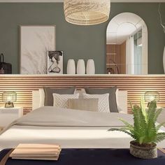 a large bed sitting in a bedroom next to a plant on top of a table