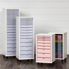 three different colored drawers sitting on top of each other in front of a white wall