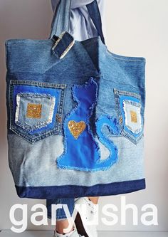 a woman holding a blue jean purse with gold sequins