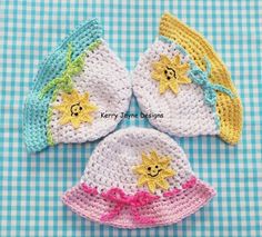 three crocheted hats with stars on them sitting on a blue and white checkered table