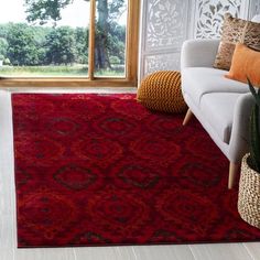 a living room with a couch, chair and rug on the floor in front of a window