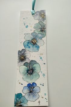 a bookmark with blue flowers painted on it