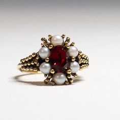 A Vintage 1973 Avon "ROSEGLOW" CLUSTER RING with a Gold Tone Finish and Faux Ruby / Garnet and Pearls -  Rings have "Adjustable Sizes": Medium - 5.5 to 7. This 51-year-old item is in very good condition Vintage Pearl Ring With Gemstone, Vintage Red Gemstone Cluster Ring, Vintage Gemstone Flower Ring For Anniversary, Vintage Red Cluster Ring For Wedding, Heirloom Red Cluster Ring With Birthstone, Antique Red Cluster Ring For Anniversary, Antique Red Cluster Ring Gift, Vintage Red Ruby Birthstone Ring, Vintage Red Ruby Ring Birthstone