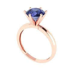 a rose gold engagement ring with a blue sapphire stone in the center, on a white background