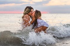 two women are kissing in the ocean water