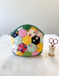 a small patchwork purse next to a pair of scissors