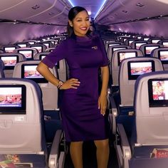 a woman standing in the aisle of an airplane