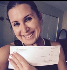 a smiling woman holding up a cheque check