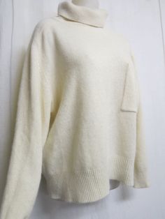 "Plush White Sweater 1990 Sarah Spencer Oversize and crazy soft! What an elegant twist on a classic white sweater! Chest pocket Lambs wool, angora and nylon blend  (NO shedding) Keep warm and make a fashion statement too! Excellent condition  all washed and ready to go Large 20\" Dropped shoulder 50\" chest. 44\"hip with stretch 19\" sleeve from under arm 26\" length Always wash in cold water and this will last a lifetime   https://www.etsy.com/shop/BelindasStyleShop" Cozy Fall Sweater With Side Pockets, Long Sleeve Sweater With Side Pockets For Winter, White Relaxed Fit Sweater For Work, Cream Oversized Sweater For Work, Oversized Cream Sweater For Work, Oversized Off-white Sweater For Fall, Oversized Classic Sweater In Winter White, White Sweater With Pockets For Layering, White Layering Sweater With Pockets