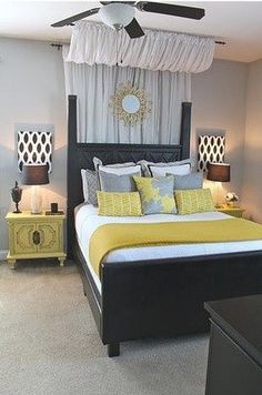 a bed with yellow and gray pillows in a bedroom