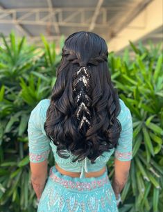 the back of a woman's head with long hair in a half - up braid