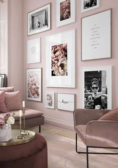 a living room with pink walls and pictures on the wall above the couch, coffee table